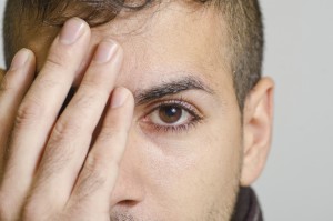 Young man coverin eye
